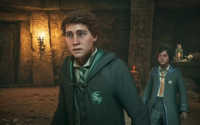 Hogwarts Legacy Deluxe Edition Switch NSP Two Hogwarts students in Slytherin and Ravenclaw robes standing in a torch-lit stone chamber